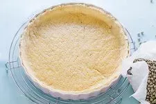 Blindgebackener Quiche Teig nach dem Entfernen der Hülsenfrüchte, goldbraun.