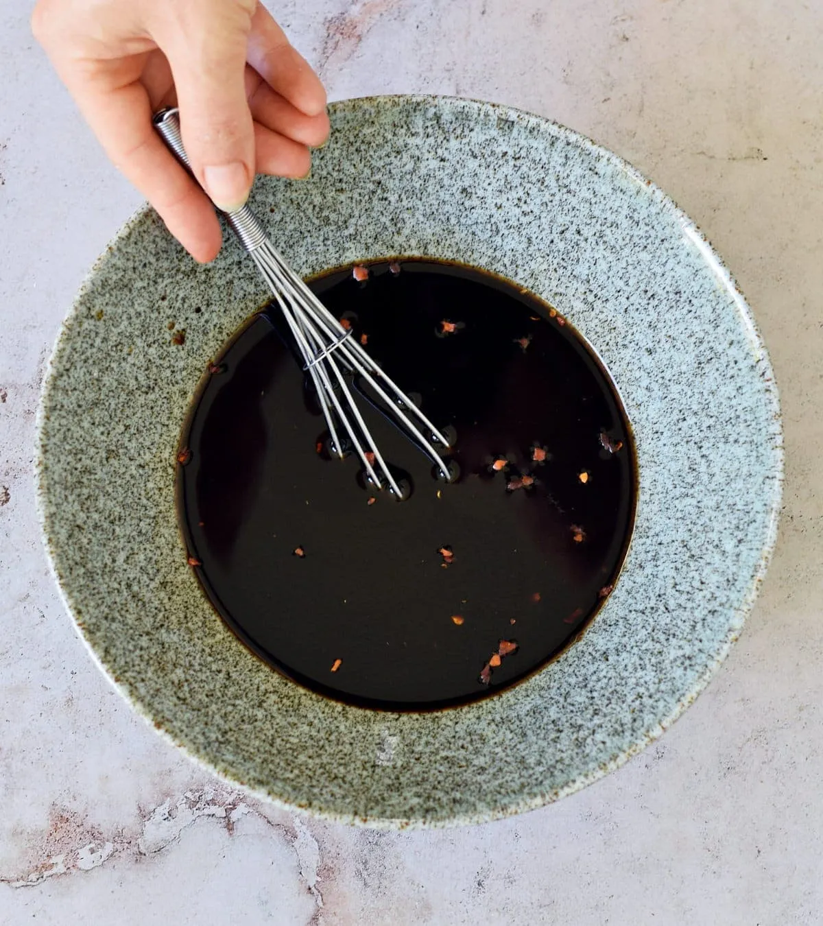 Braune Asia Würzsauce in Schale mit Schneebesen