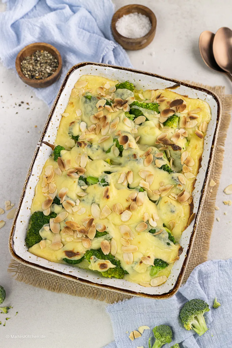 Brokkoli-Kartoffelbrei-Auflauf, goldbraun gebacken, mit cremiger Käsesauce und knusprigen Mandelblättchen.