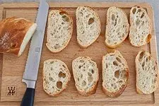 Brot für Bruschetta wird geschnitten und geröstet