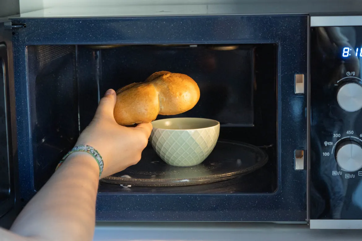 Brötchen auf einem Wasserglas in der Mikrowelle für schnelles Aufbacken