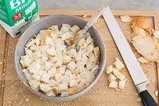 Brotwürfel weichen in Milch ein, als Vorbereitung für die Hackfleischfüllung der Paprika.