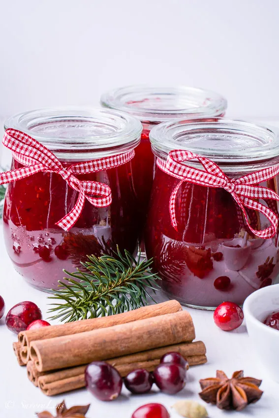 Bunte Mischung aus frischen und gefrorenen Früchten wie Birnen, Cranberries, Erdbeeren und Himbeeren, bereit für die Zubereitung von Weihnachtsmarmelade.