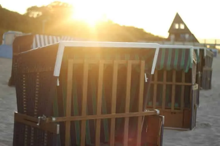 Bunte Strandkörbe am Strand der Ostsee unter blauem Himmel im Sommer