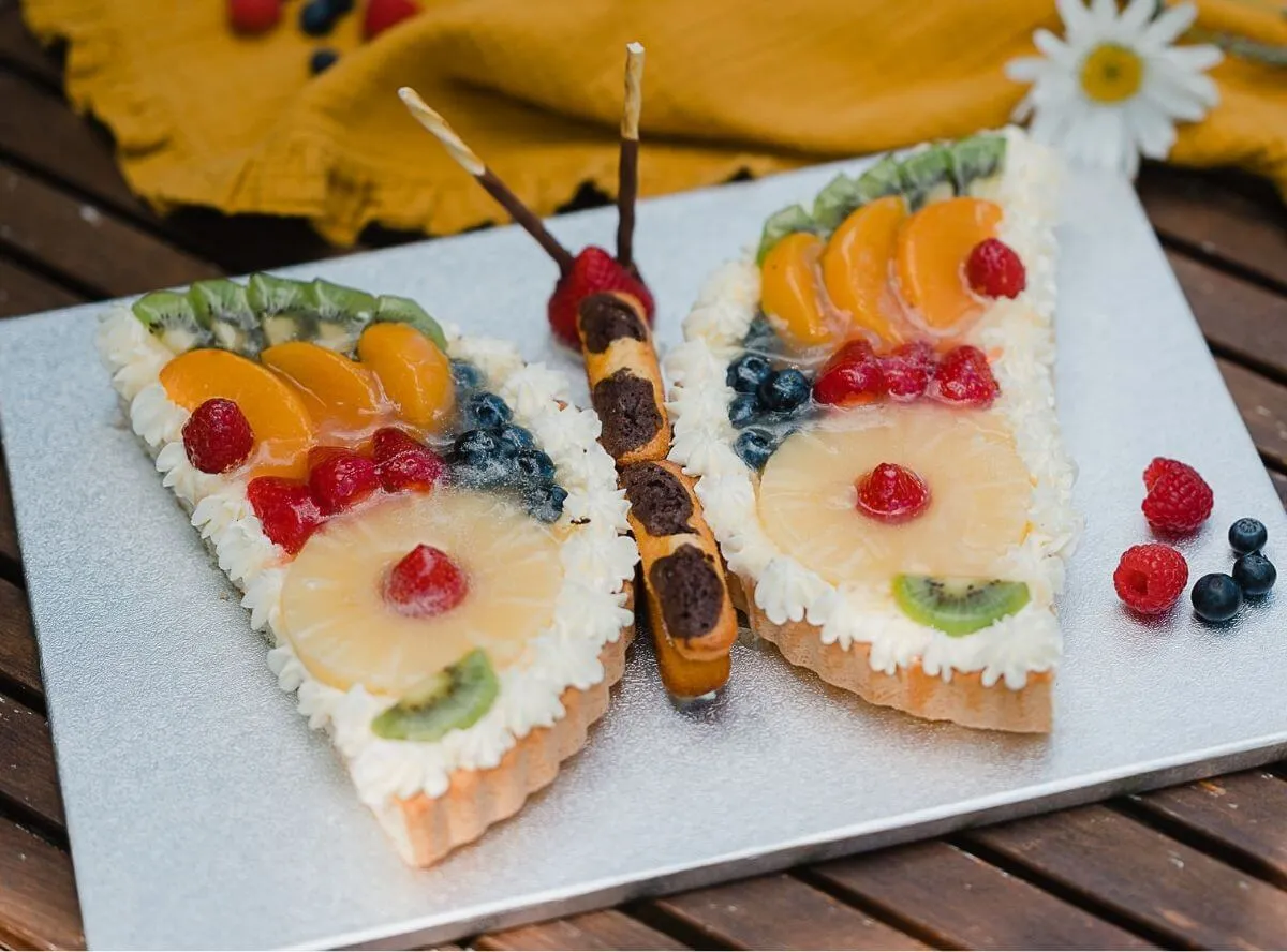 Bunter Schmetterlingskuchen mit frischen Früchten verziert, perfekt für den 3. Geburtstag eines Mädchens.