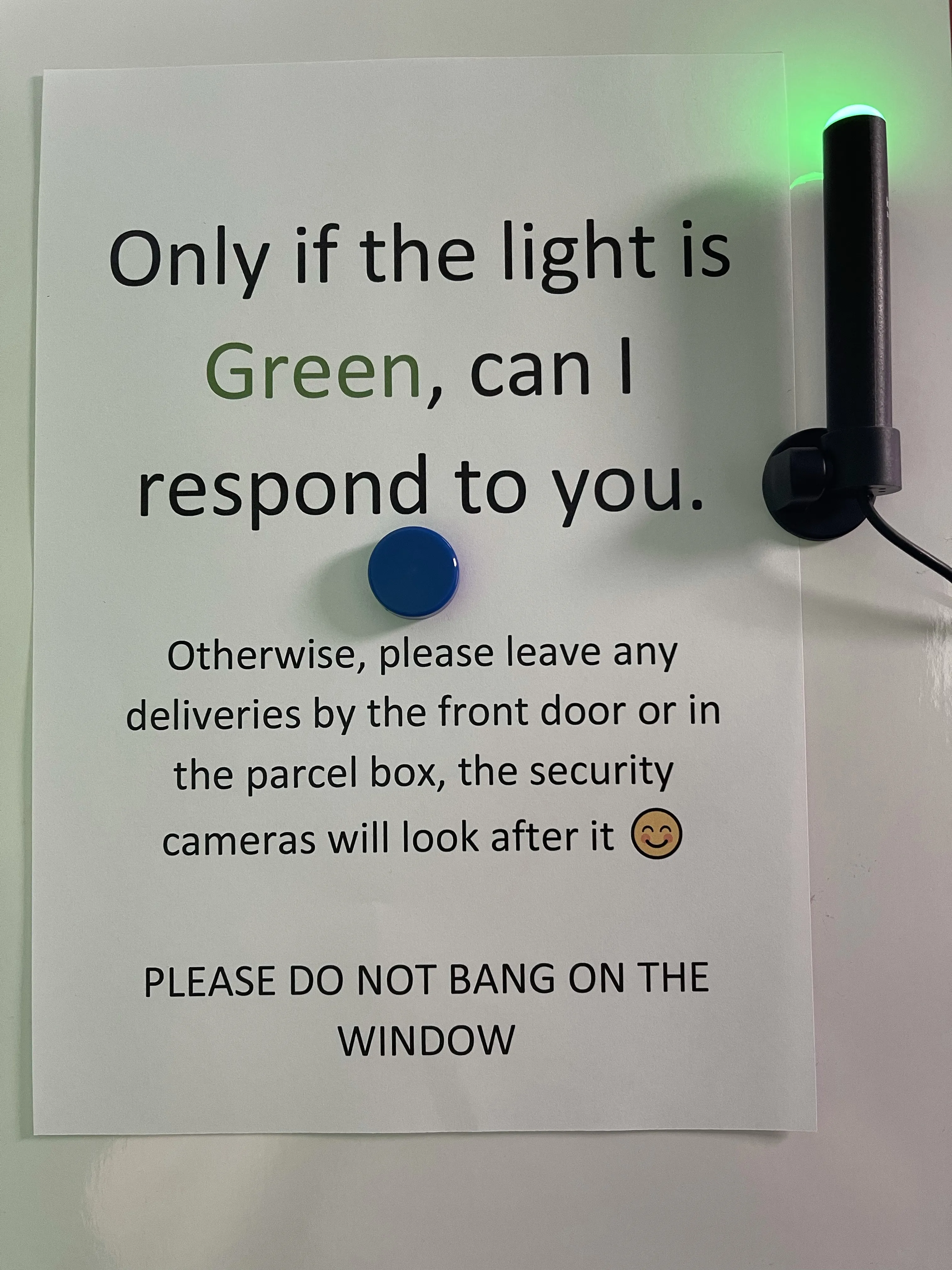 Busylight leuchtet rot vor einem Fenster im Homeoffice