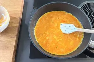 Butter in der Pfanne zerlassen und Ei-Masse hinzugeben, um ein leckeres Omelett zu backen.