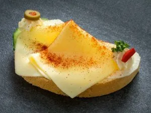 Butterkäse auf einem hellen Brötchen mit Schnittlauch