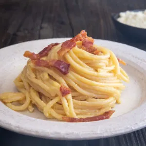 Carbonara auf einem Teller mit Guanciale als Garnitur
