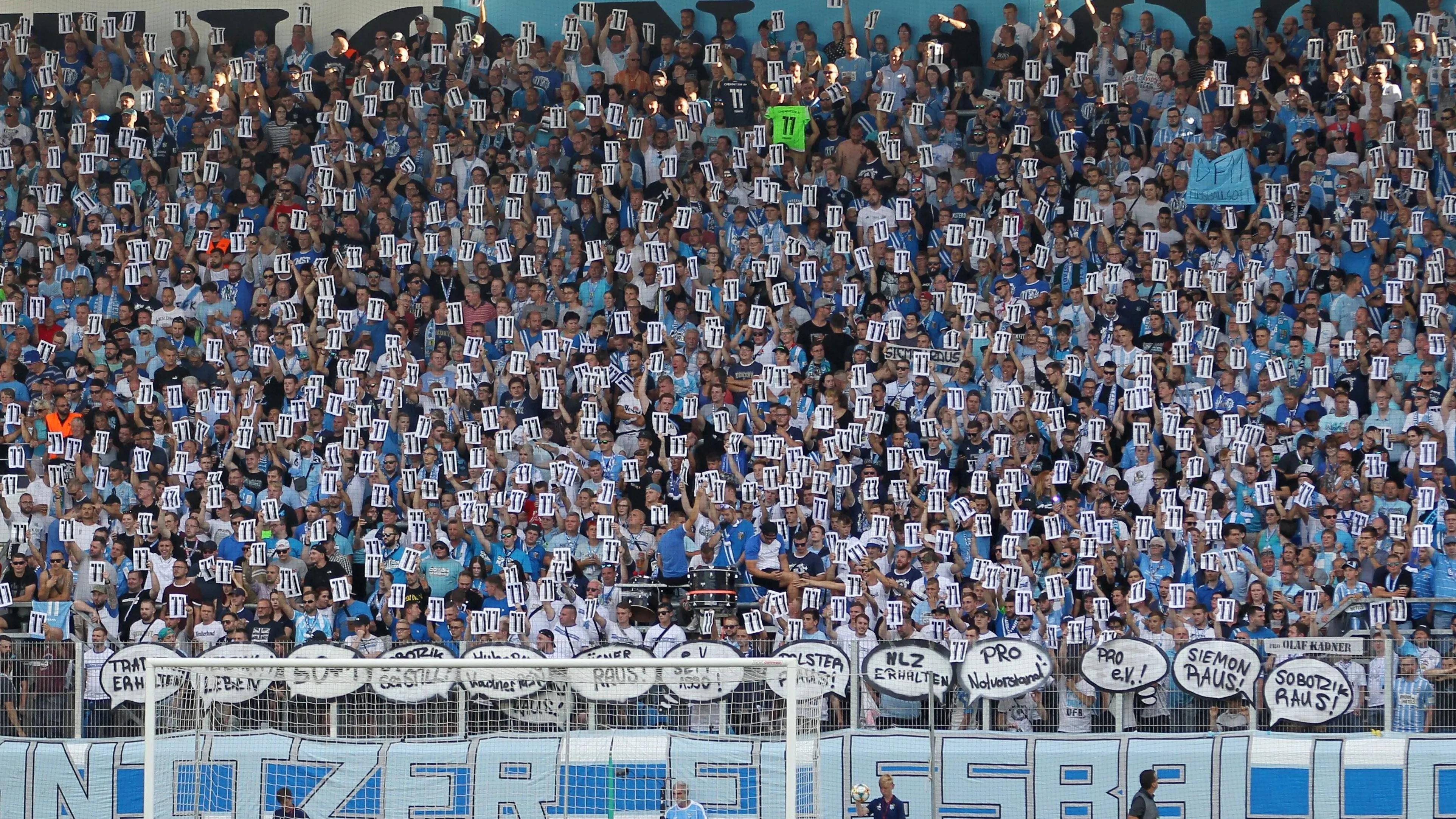 Chemnitzer FC Fans zeigen Solidarität mit dem entlassenen Kapitän Daniel Frahn, indem sie dessen Trikotnummer hochhalten, inmitten von Kontroversen um rechtsextreme Sympathien der Fanszene.