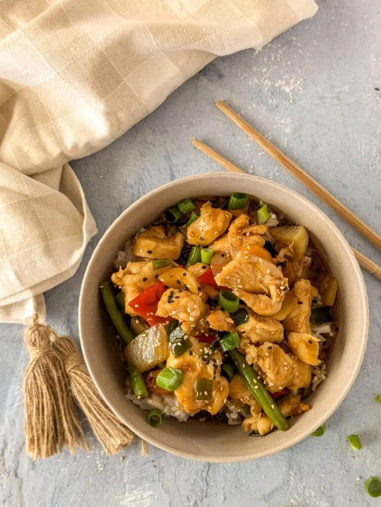 Chinesisches Hähnchengericht mit viel Gemüse und dunkler Sauce, angerichtet in einer Schale.