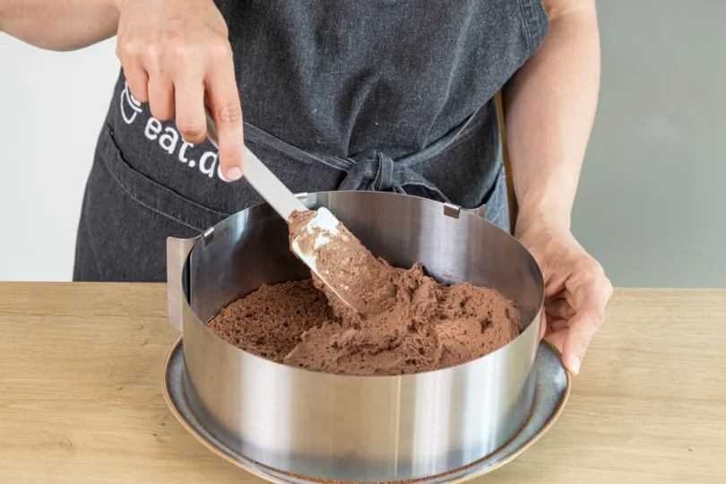 Creme auf der Schokosahnetorte verstreichen