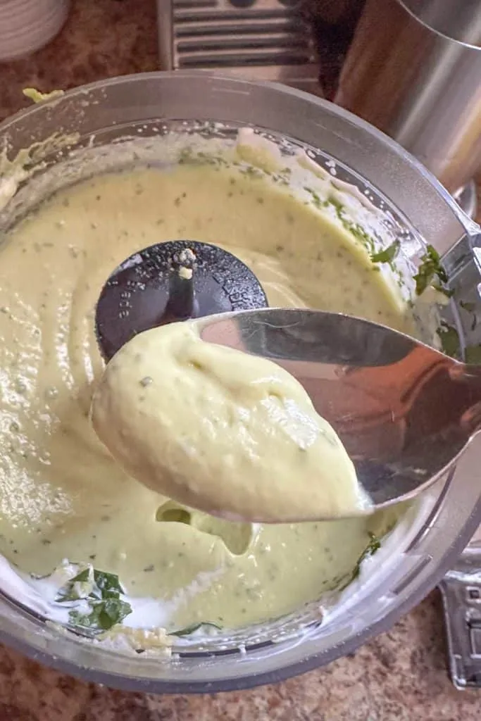 Creme in einer Küchenmaschine mit einem Löffel.