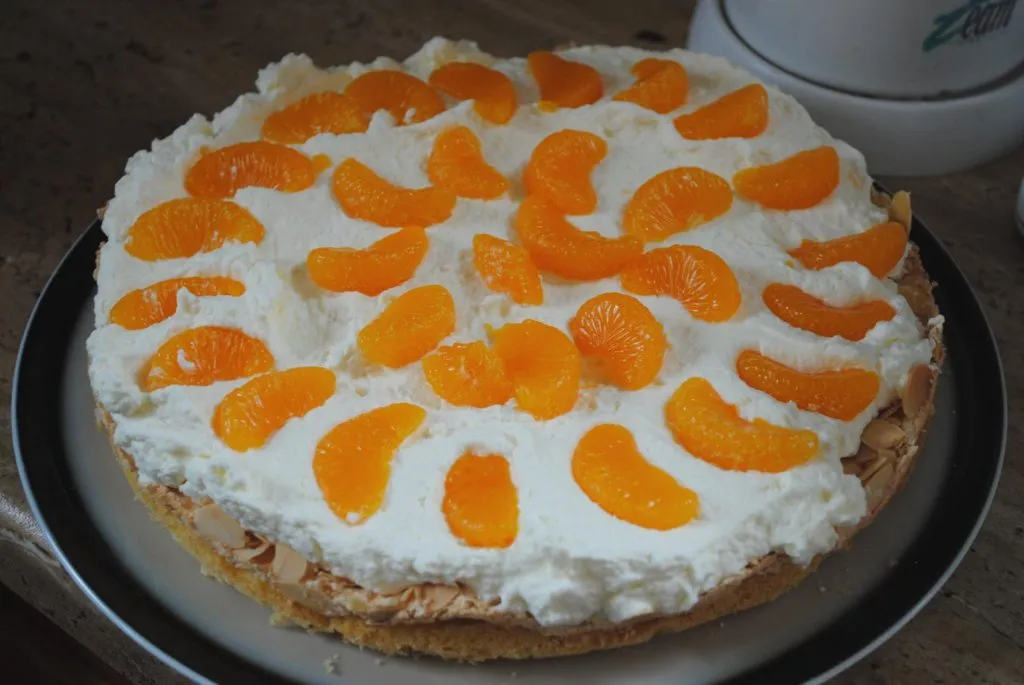 Cremige Füllung mit Mandarinen auf dem Tortenboden