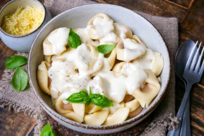 Cremige Käsesoße auf Tortellini serviert, goldbraun und appetitlich angerichtet, ein einfaches Käsesoße Rezept.