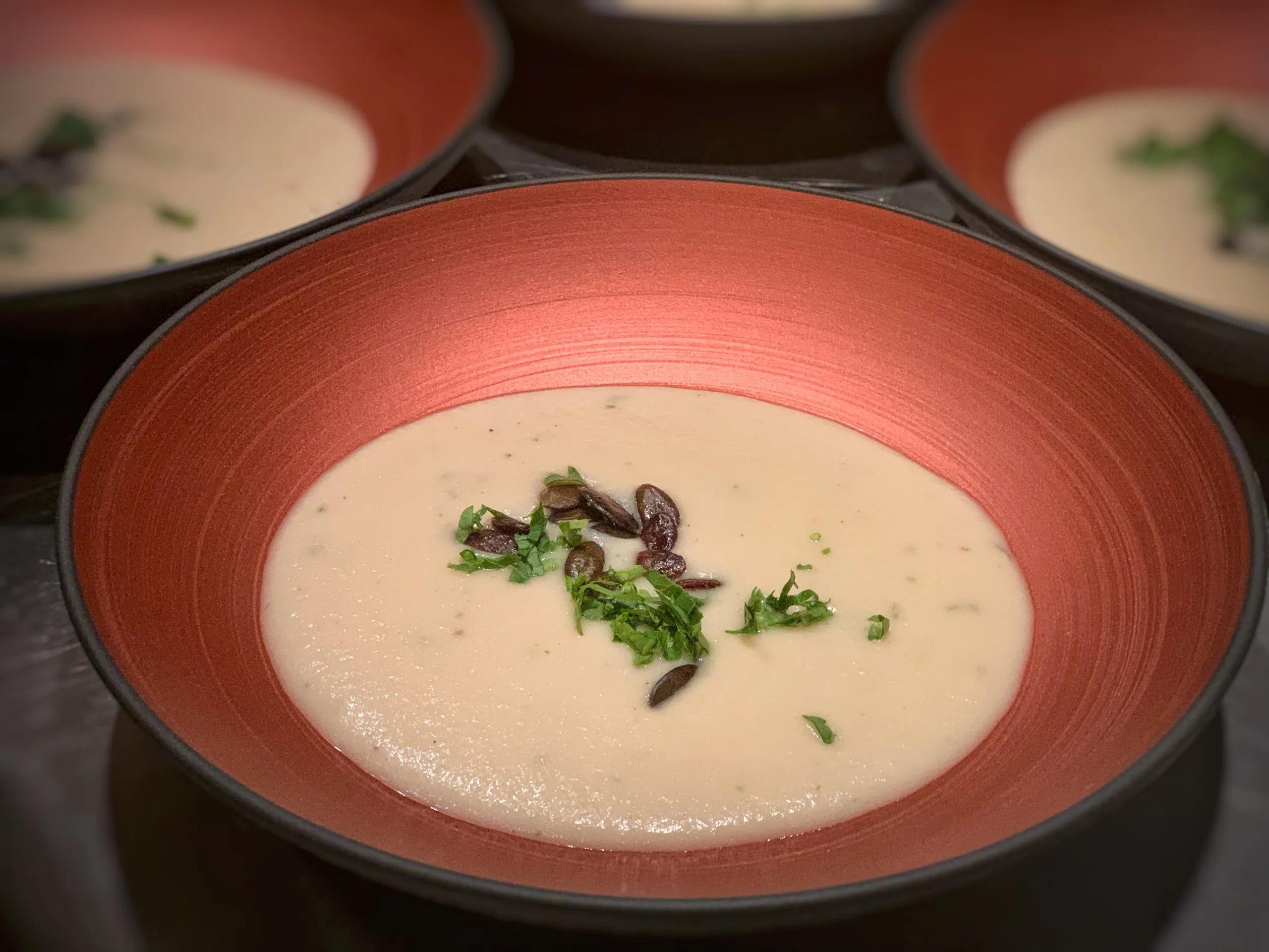 Cremige Knoblauchcremesuppe mit gerösteten Kürbiskernen und frischer Petersilie