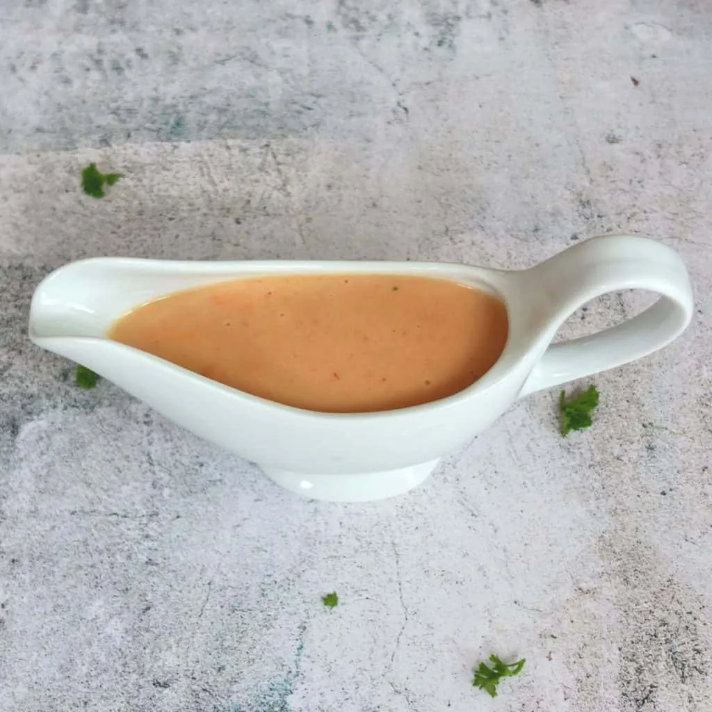 Cremige Rahmsauce in einem Saucenlöffel, leicht mit Thymian bestreut