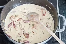 Cremige Rahmsoße mit Crème fraîche und Sahne köchelt sanft, perfekt für zarte Rezepte mit Rinderfilet wie Stroganoff.