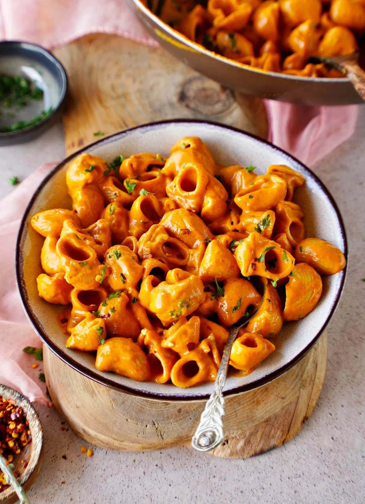 Cremige vegane Nudeln mit Paprikasoße, Cashewmus und gerösteter Paprika in einer Schüssel mit Löffel, ein wohltuendes Mittagessen.