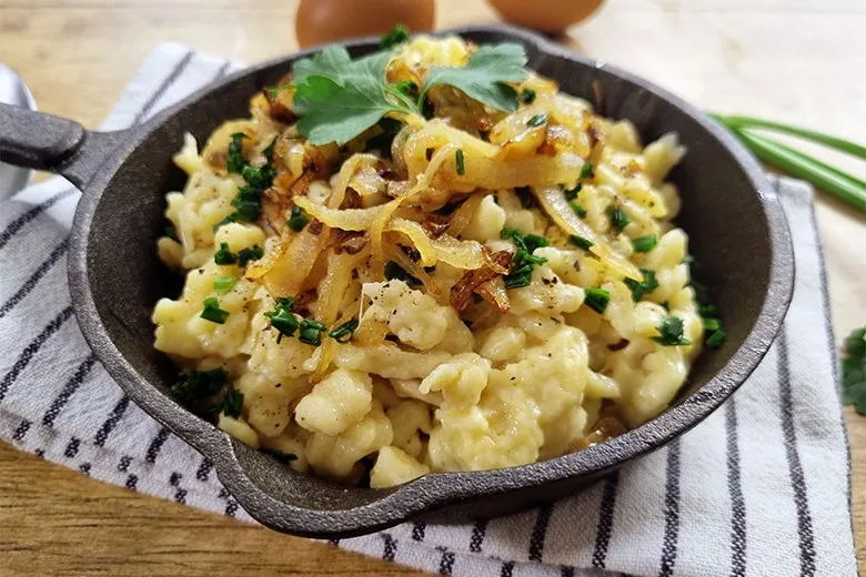 Cremige Vorarlberger Käsespätzle mit Röstzwiebeln, ein deftiges Gericht aus der österreichischen Regionalküche