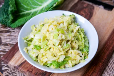 Cremiger Rahmwirsing servierfertig auf weißem Teller als traditionelle deutsche Beilage