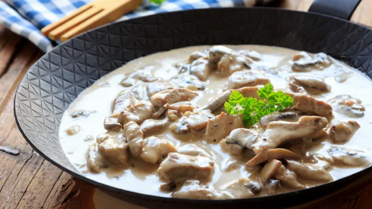 Cremiges Putengeschnetzeltes mit Champignons und Petersilie auf Reis angerichtet
