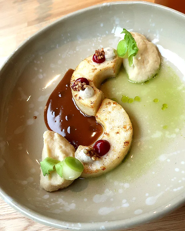 Das innovative Signature Dish &quot;Sellerie von Kopf bis Fuß&quot; aus der Hummelbude Essen, kunstvoll präsentiert mit Hafersauce und Himbeergel.