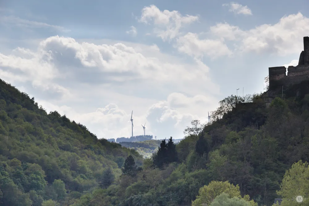 Das kleine Dorf Rheindiebach am Rhein mit modernen Windkraftanlagen im Hintergrund