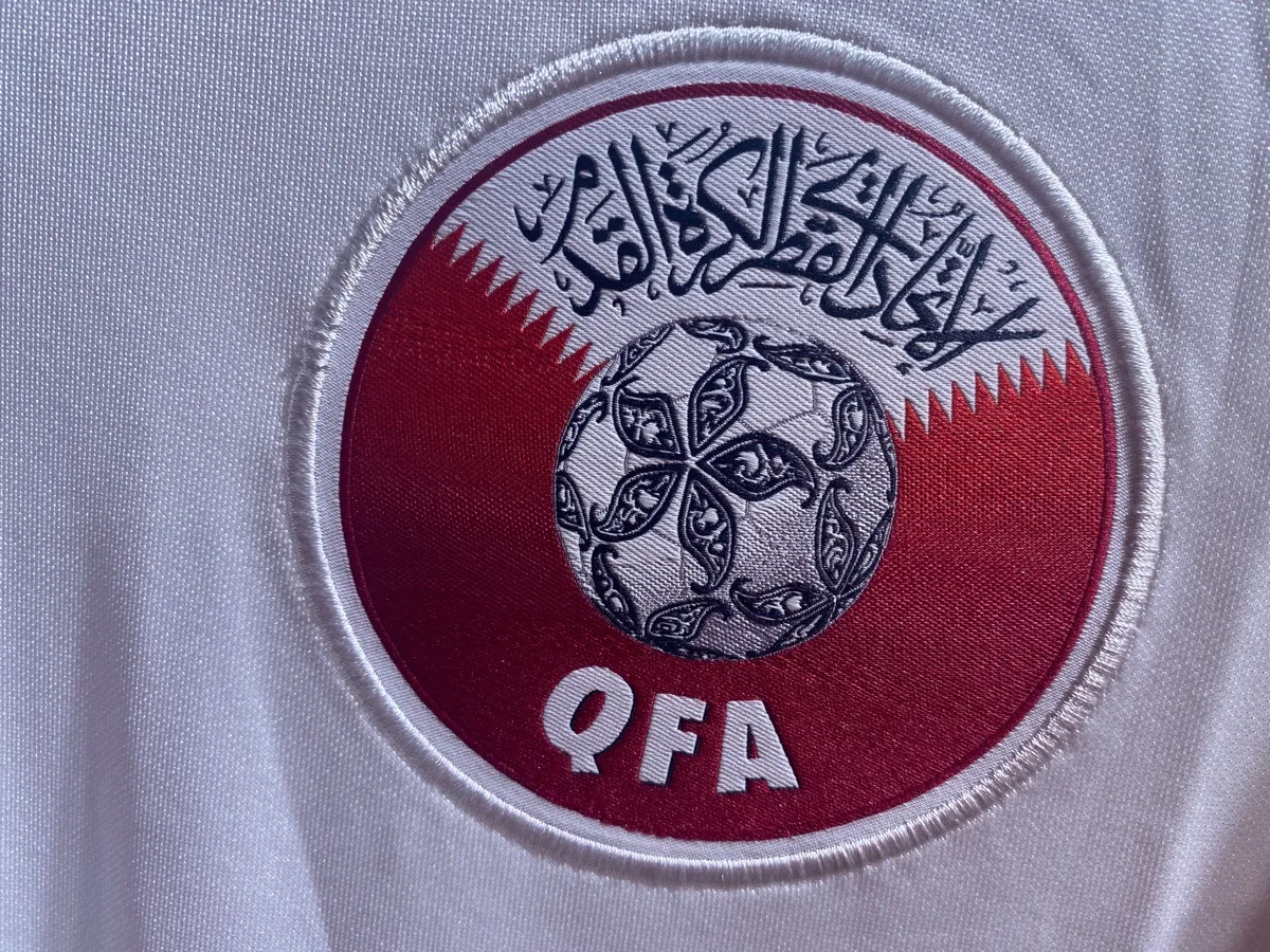 Das Logo des Fußballverband von Katar auf dem roten Heimtrikot 2022.