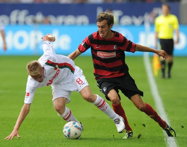 Defensiver Mittelfeldspieler Julian Schuster von SC Freiburg im Zweikampf gegen Augsburg.