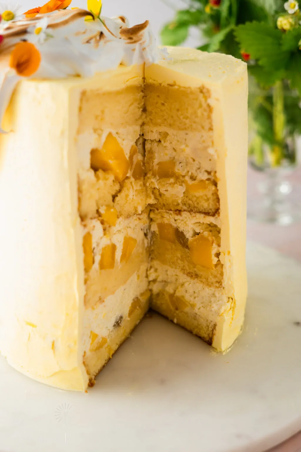 Dekorative Baiserhaube auf einer Mango-Sahne-Torte