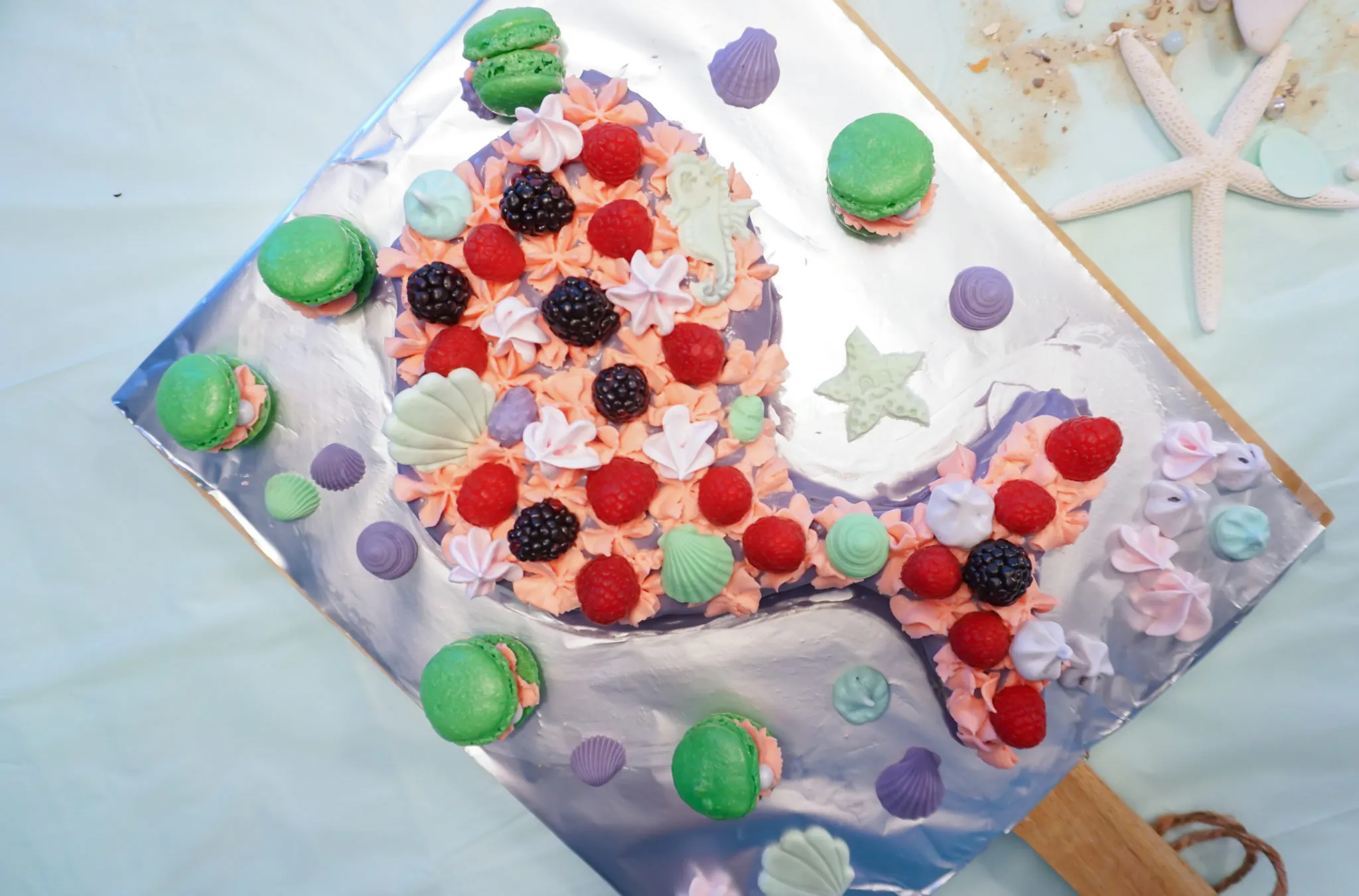 Dekorierter Fantakuchen mit Meerjungfrauen-Thema, besetzt mit rosa, lila und mintfarbenen Macarons