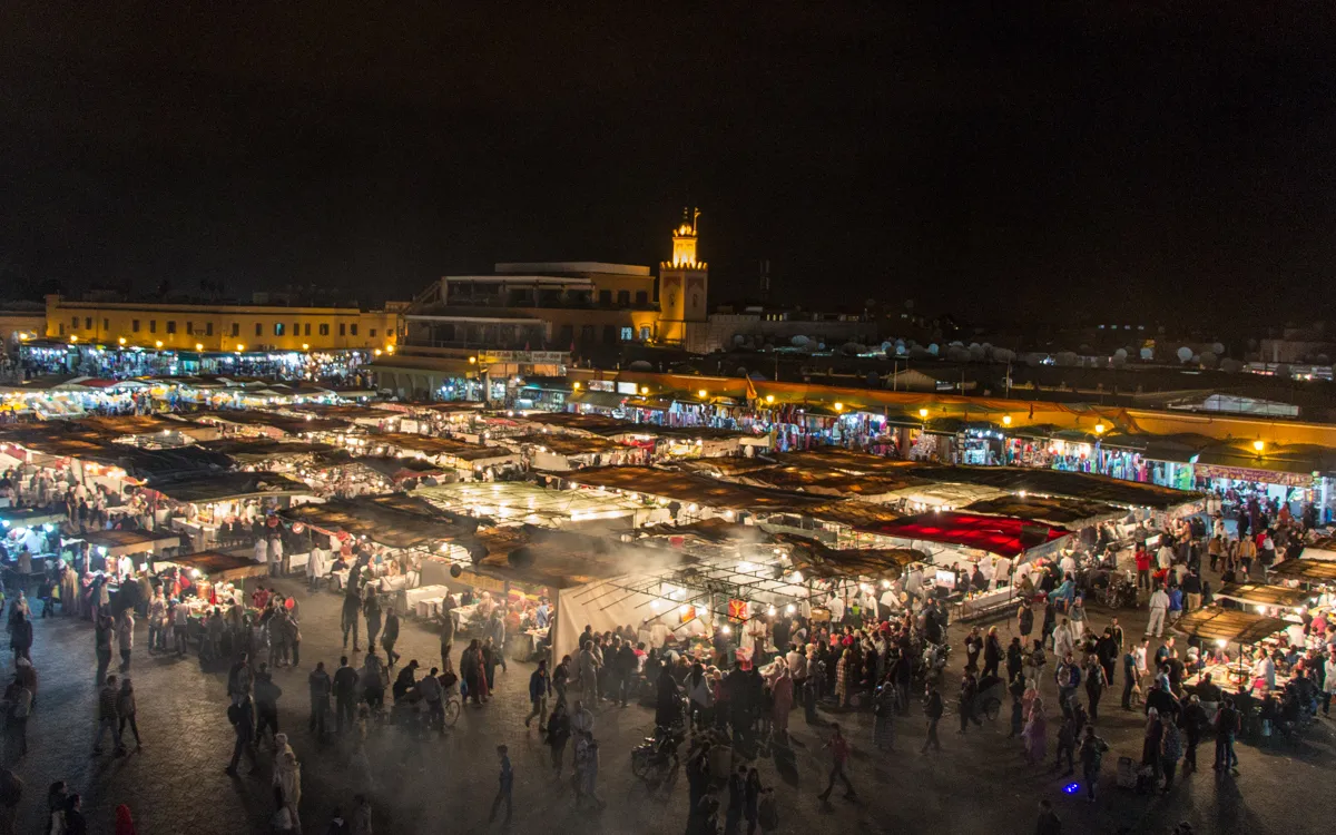 Der belebte Djemaa el-Fna in Marrakesch, Marokko, ein pulsierender Ort, der im Mai mit angenehmen Temperaturen zum Verweilen einlädt.