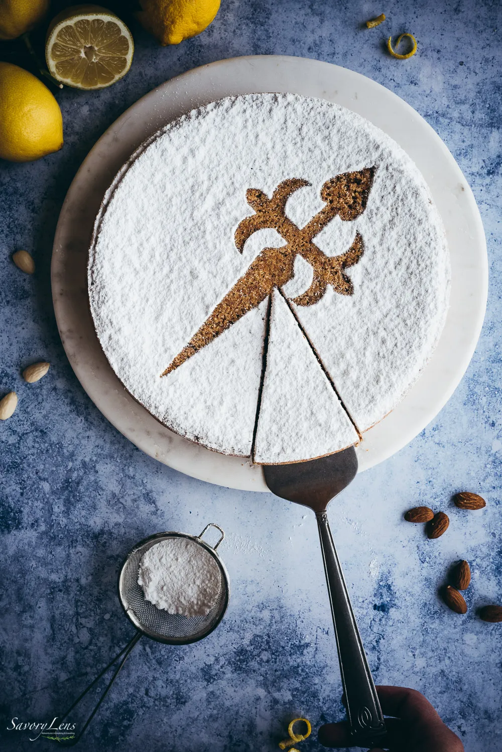 Der fertig bestäubte spanische Mandelkuchen Tarta de Santiago mit dem charakteristischen Jakobskreuz aus Puderzucker.