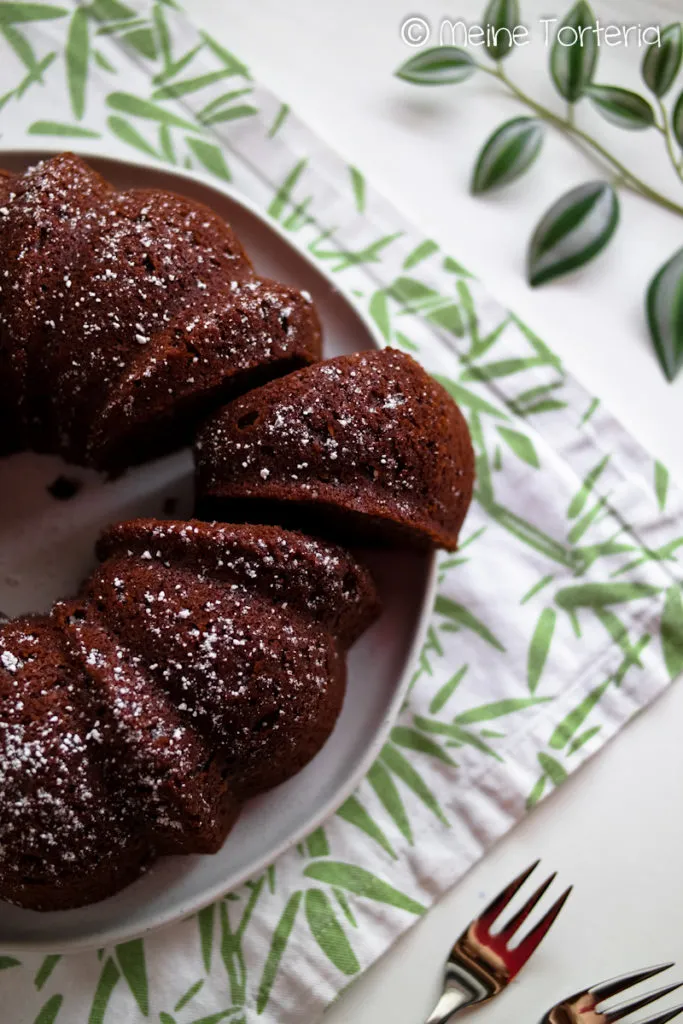 Der fertig gebackene, mit Puderzucker bestreute Paradiescreme-Kuchen in einer verzierten Gugelhupfform, bereit zum Servieren