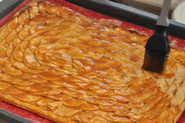 Der fertige Apfelkuchen wird mit Salzbutterkaramell bestrichen und kurz gebacken.