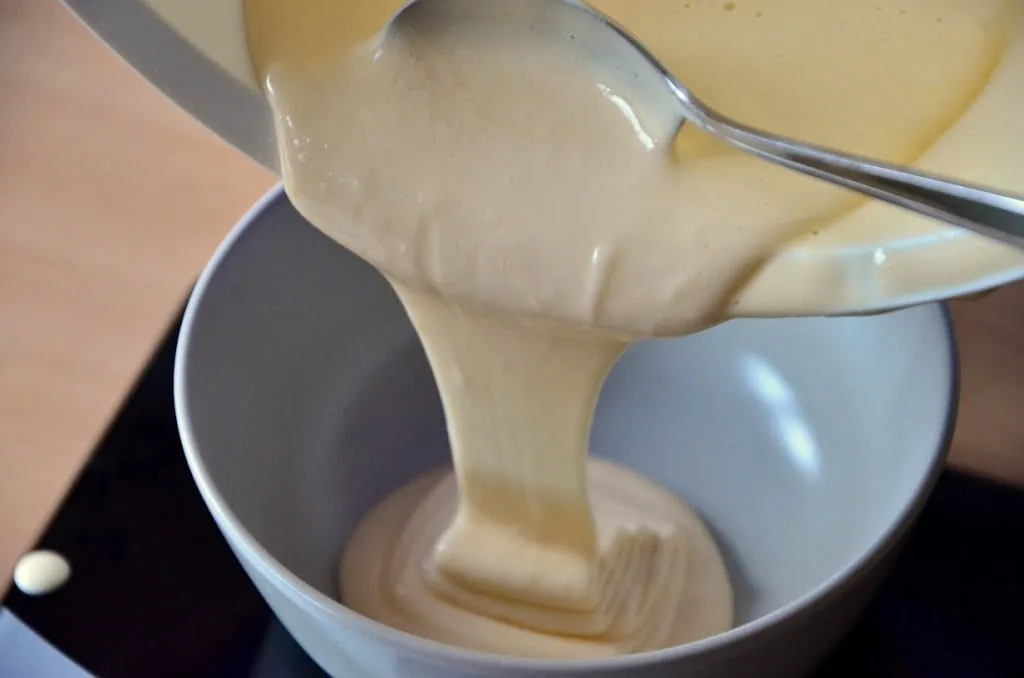 Der fertige Biskuitteig für die Regenbogen-Torte wird gleichmäßig auf sechs separate Schüsseln verteilt