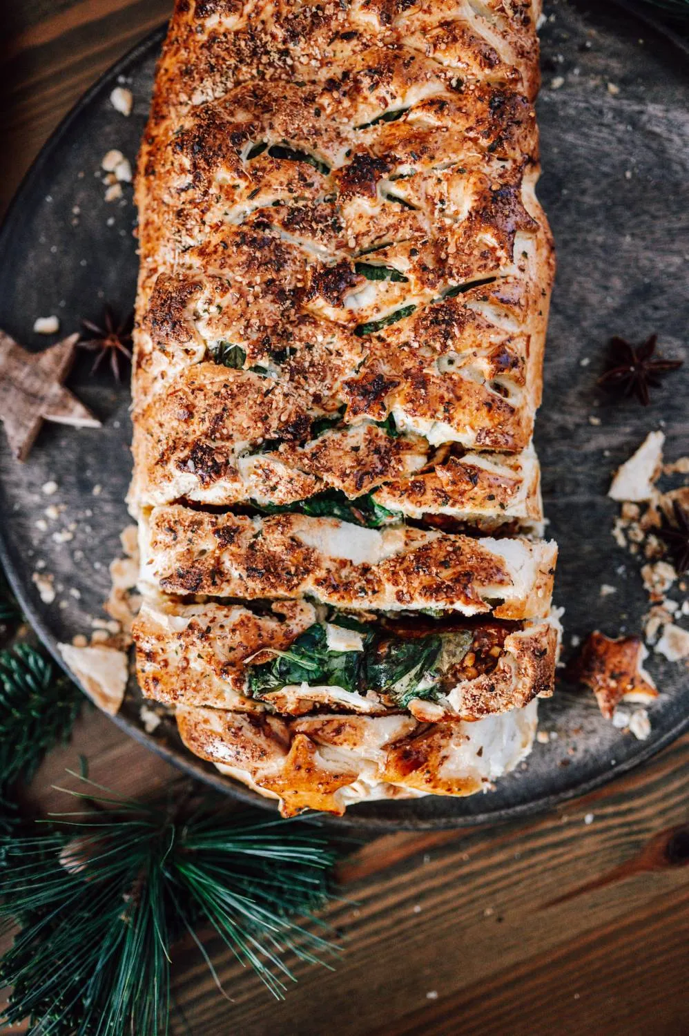 Der fertige vegetarische Weihnachtsbraten auf einem Schneidebrett, bereit zum Anschneiden, mit Blätterteigsternen verziert