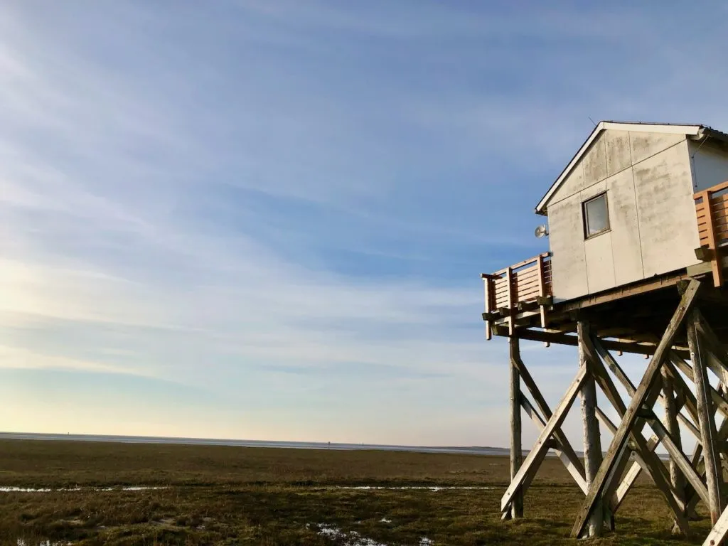 Der ikonische breite Strand und die Pfahlbauten von St. Peter Ording, nahe der Dünen Therme