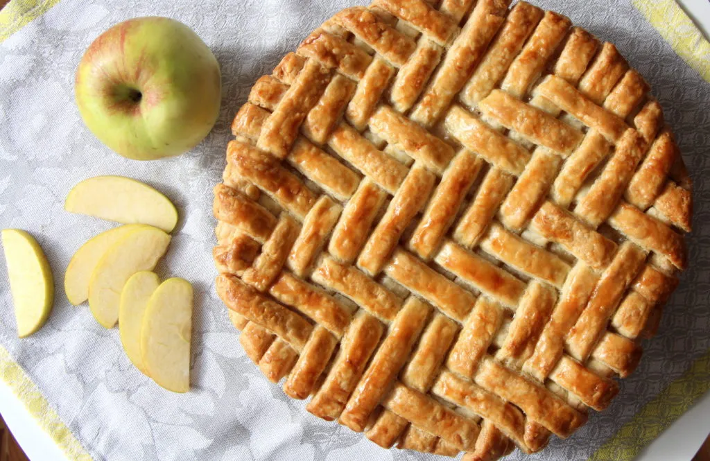 Der rohe Teig für amerikanischen Apfelkuchen, kurz vor dem Ausrollen, mit sichtbaren Butterstückchen für eine blättrige Textur.