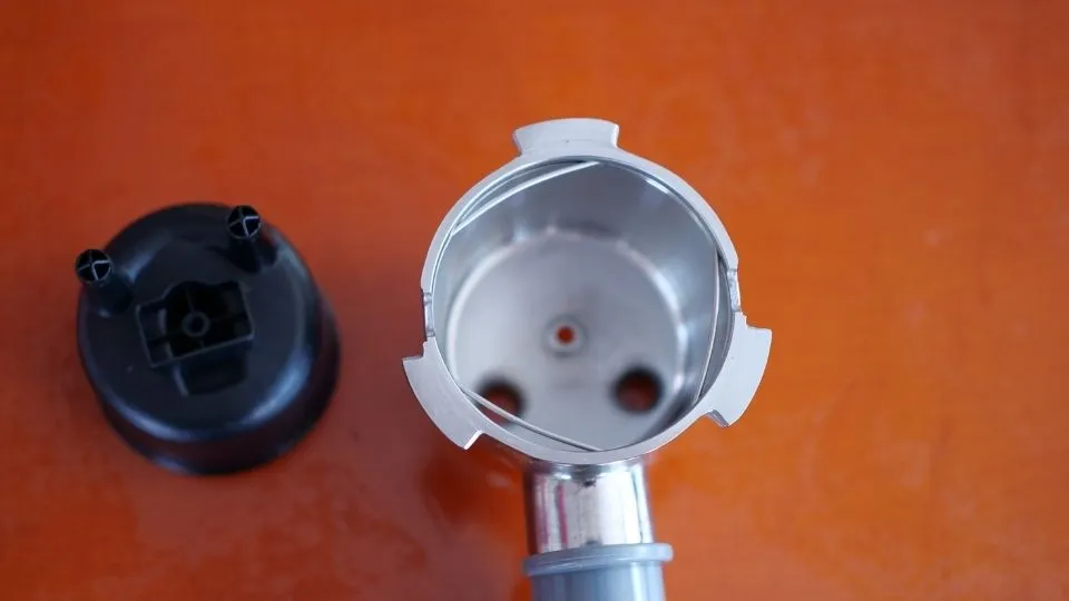 Der Siebträger der Smeg ECF01 Kaffeemaschine nach dem Ausbau des Plastik-Inlays für die Verwendung einwandiger Siebe.