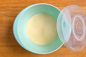 Der vorbereitete Pfannkuchenteig ruht in einer Schüssel, um die Konsistenz zu perfektionieren und das Mehl aufquellen zu lassen.