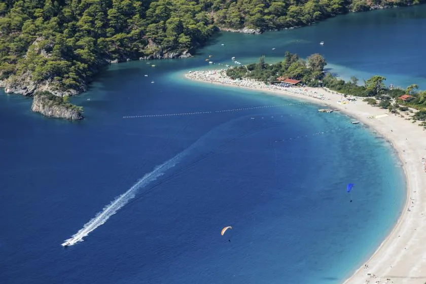 Der weite Çalış Strand bei Fethiye, ein idealer Ort für Badeurlaub und Wassersport in der Türkei.