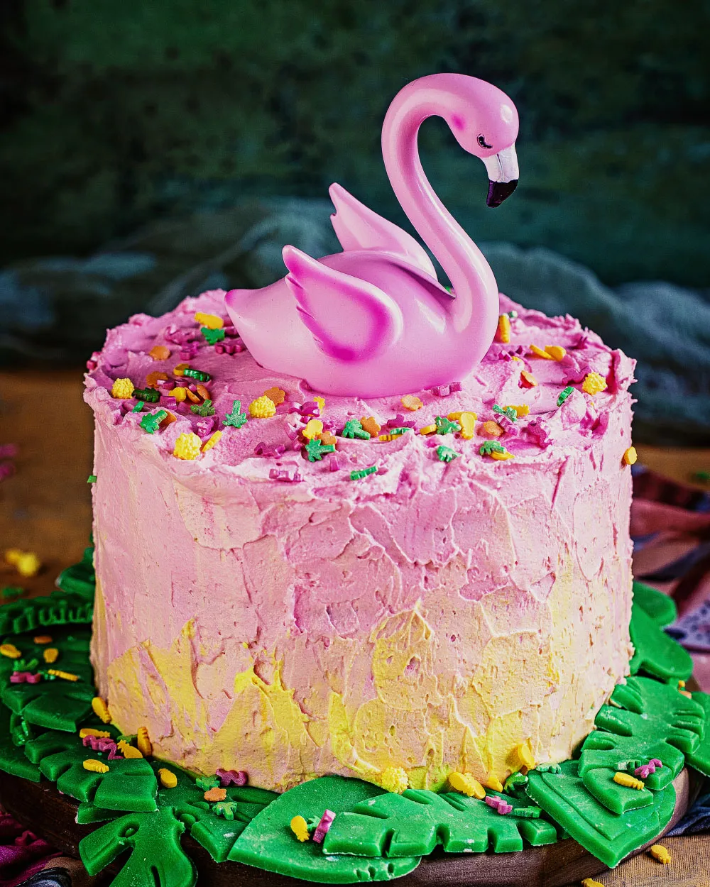 Detailansicht der essbaren grünen Marzipanblätter am Fuß des Flamingo-Geburtstagskuchens.