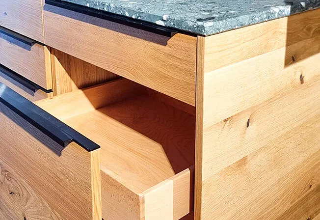 Detailansicht einer Massivholzschublade, die die hochwertige Verarbeitung und Holzmaserung zeigt