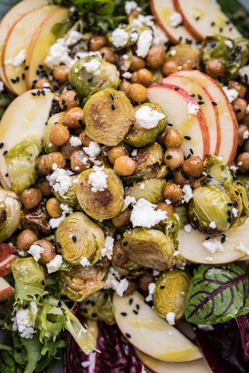 Detailansicht eines frischen Rosenkohl Salats mit knusprigen Kichererbsen und Tahini-Dressing
