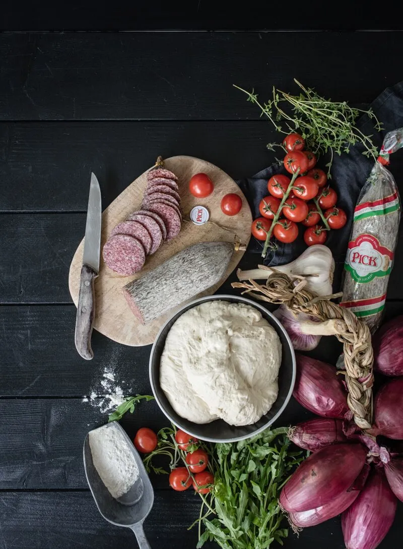 Detailansicht eines Stücks Pan Pizza mit fluffigem Teig und geschmolzenem Käse, bereit zum Genießen an Silvester