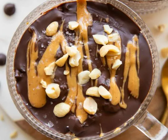 Detailansicht von Snickers Overnight Oats in einem Becherglas, verziert mit Topping.