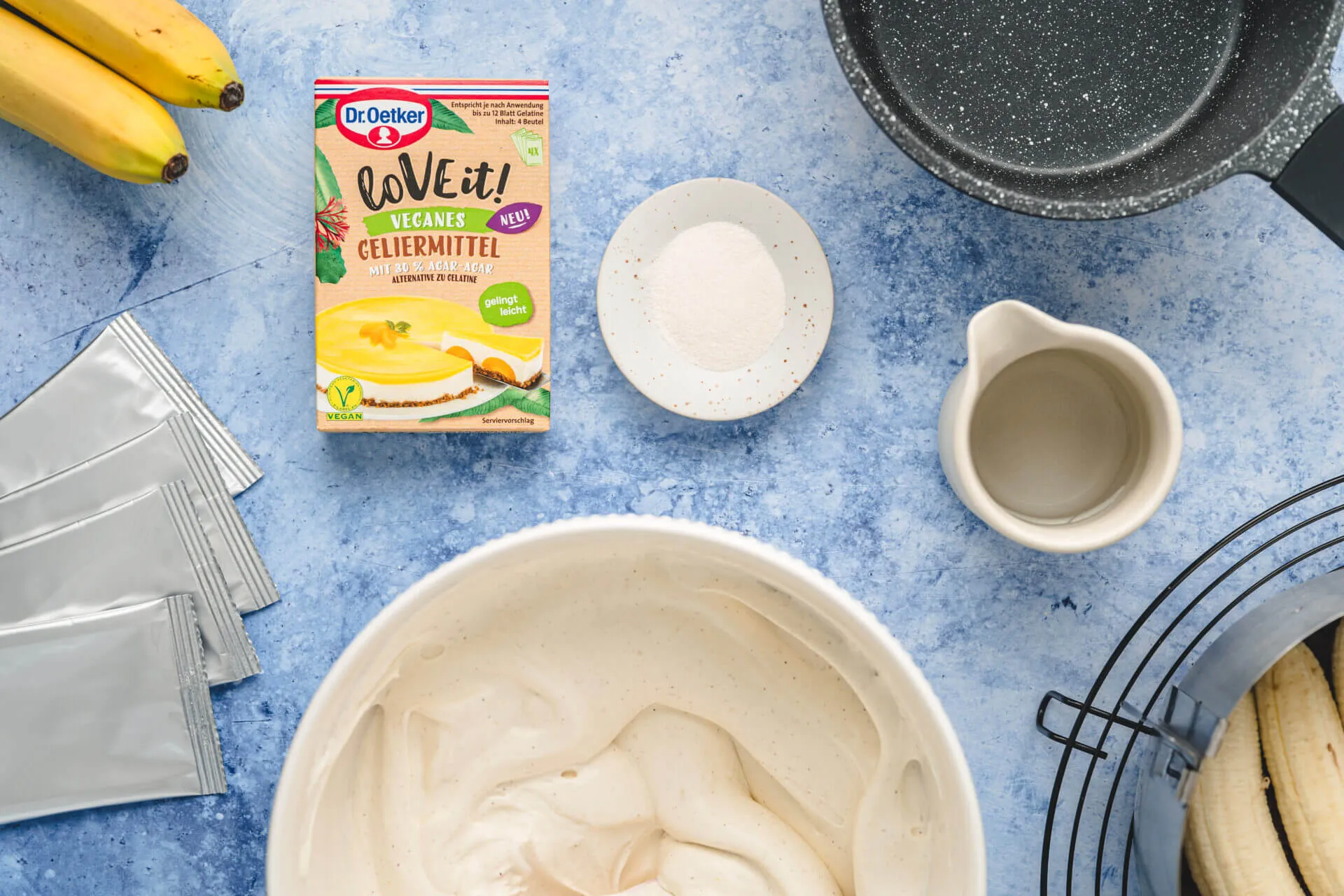 Detailaufnahme der Oberseite einer dekorierten Schoko-Bananen-Sahne-Torte mit Schokoladenstreuseln und Sahnetupfern.