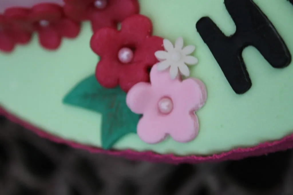 Detailaufnahme einer kleinen, bunt dekorierten Geburtstagstorte mit Fondant.